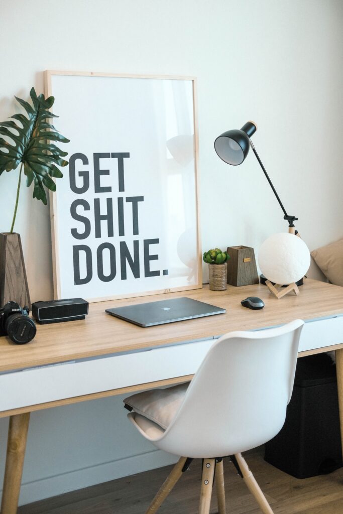 An office desk under a poster with the words Get Shit Done