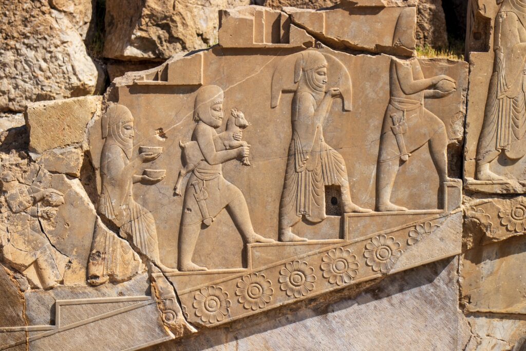 An egyptian wall carving of people walking up stairs
